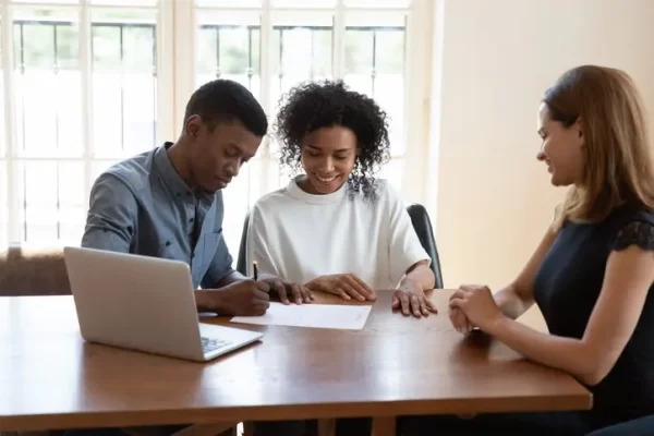 Excited african American couple close deal at agent office